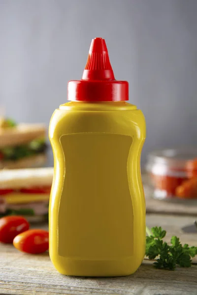 Envase de botella de mostaza amarilla sin etiqueta. Sándwich de desayuno sobre fondo. Productos alimenticios . — Foto de Stock