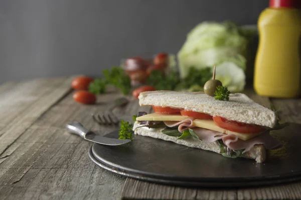 Homemade club sandwich. Toasted white bread triangles with ham, cheese fresh vegetables. Wooden table. — Stock Photo, Image