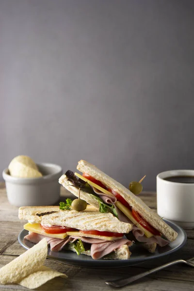 Homemade club sandwich. Toasted white bread triangles with ham, cheese fresh vegetables. Wooden table. — Stock Photo, Image