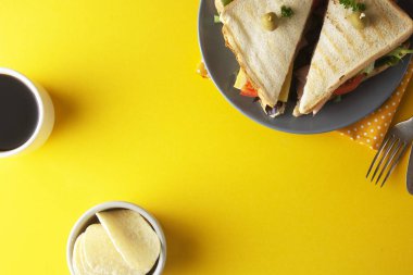 Jambonlu sandviç. Jambon, peynir taze sebze ile tost çift panini. Sarı arka plan. Düz yatıyordu.