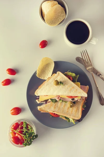 Sándwich casero. Panini doble tostado con jamón, queso y verduras frescas. Snack en el trabajo o el almuerzo. Fondo claro . — Foto de Stock