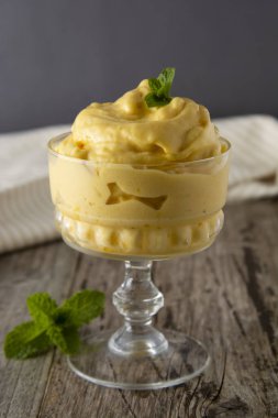 Cam bardak, rustik ahşap arka plan ev yapımı mango veya limon dondurma. Vintage tarzı.