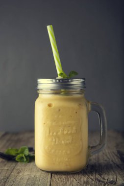 Mason kavanoz bardak, rustik ahşap arka plan ev yapımı mango, limon dondurma veya süt sallamak. Vintage tarzı.