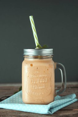 Mason kavanoz bardak, rustik ahşap arka plan ev yapımı mango, limon dondurma veya süt sallamak. Vintage tarzı.