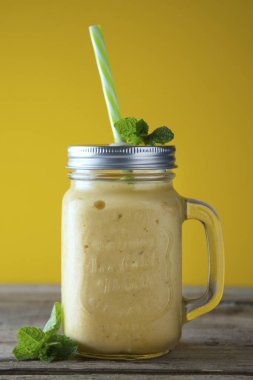 Mason kavanoz bardak, rustik ahşap arka plan ev yapımı mango, limon dondurma veya süt sallamak. Vintage tarzı.