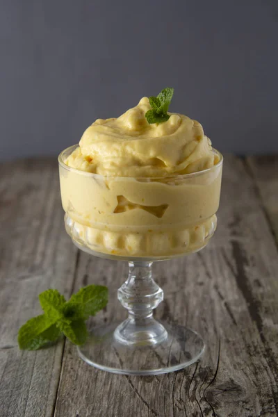 Hausgemachtes Mango-oder Zitroneneis im Glasbecher, rustikaler Holzhintergrund. Jahrgangsstil. — Stockfoto