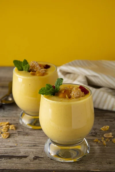Mango-Milchshake oder Smoothie im Glas auf dem alten Holzgrund. Mango Milchshake. Erfrischungsgetränk im Sommer. — Stockfoto