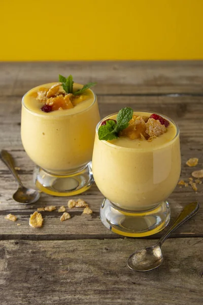 Mango-Milchshake oder Smoothie im Glas auf dem alten Holzgrund. Mango Milchshake. Erfrischungsgetränk im Sommer. — Stockfoto