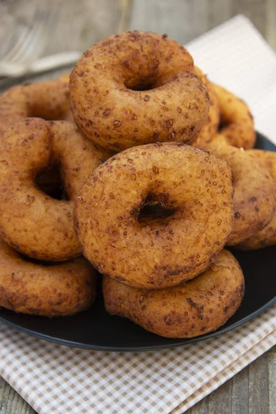 Zelfgemaakte donuts. ronde, cirkel heerlijke donuts in zwarte plaat, houten achtergrond. Geïsoleerd dessert of ontbijt. — Stockfoto