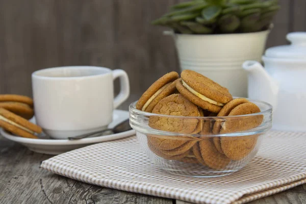 Імбирне печиво з вершками, печиво для чаю кави, на дерев'яному столі. Солодка закуска здорової їжі з кавою, чашкою чаю . — стокове фото