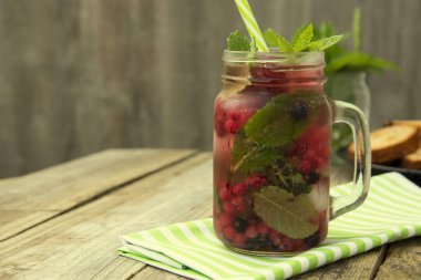 Şık taze buz, soğuk meyve çay arka plan, saman ile Mason kavanoz fincan, yaz meyve çay içeceği, ahşap arka plan. Kopyalama alanı.