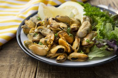 Taze lemom ile soyulmuş midye. Sağlıklı deniz ürünleri, doğal güneş ışığı, ahşap rustik masa.