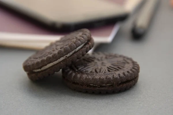 Schokokekse auf dem Arbeitstisch, süßer Snack bei der Arbeit. — Stockfoto