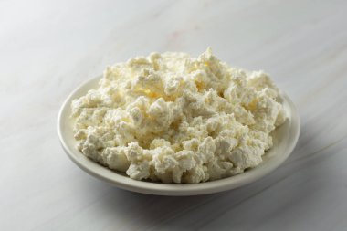 Kır köy peyniri ışık, mermer arka plan üzerinde izole. Süt ürünleri, kalsiyum ve protein. Sağlıklı kahvaltı.