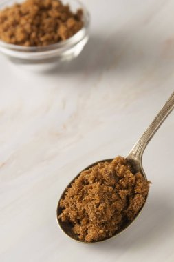 Metal kaşık kahverengi şeker parlak, mermer arka plan kopya alanı ile. Tatlı maddesi, şeker bağımlısı. Kopyalama alanı.