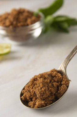 Metal kaşık kahverengi şeker parlak, mermer arka plan kopya alanı ile. Tatlı maddesi, şeker bağımlısı. Kopyalama alanı.