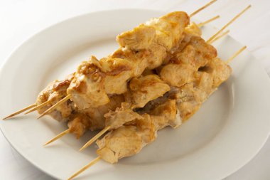 Bambu şiş kebap beyaz tabakta tavuk eti, mermer parlak arka plan. Diyet az yağlı gıda.