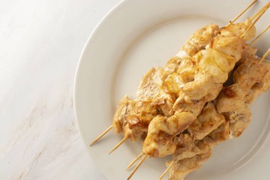 Bambu şiş kebap beyaz tabakta tavuk eti, mermer parlak arka plan. Diyet az yağlı gıda.