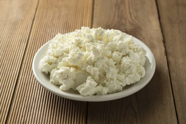 Ahşap arka planda süzme peynir. Süt ürünleri, kalsiyum ve protein. Sağlıklı kahvaltı.