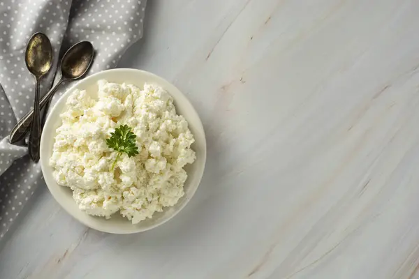 Τυρί cottage ισοφυλίστηκε στο φως, μαρμάρινη φόντο. Γαλακτοκομικά προϊόντα, ασβέστιο και πρωτεΐνες. Υγιεινό πρωινό. — Φωτογραφία Αρχείου