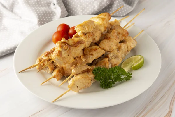 Chicken meat on bamboo skewers kebab in white plate, marble bright background. Diet low fat food. — Stock Photo, Image