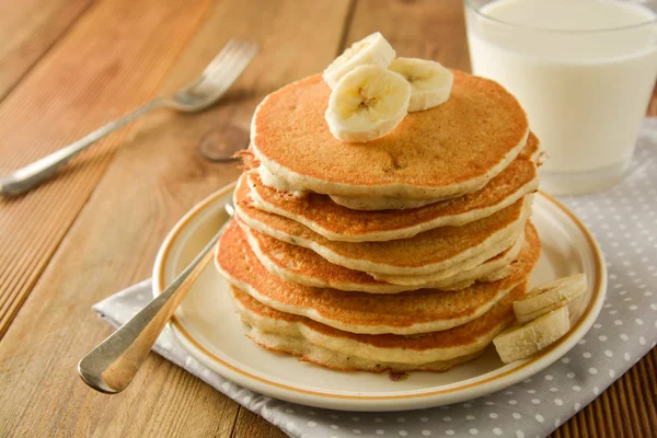 Pilha de panquecas com fatias de banana e mel, em fundo de madeira. Panquecas americanas caseiras, isoladas . — Fotografia de Stock