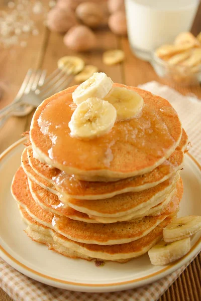 Pilha de panquecas com fatias de banana e mel, em fundo de madeira. Panquecas americanas caseiras, isoladas . — Fotografia de Stock