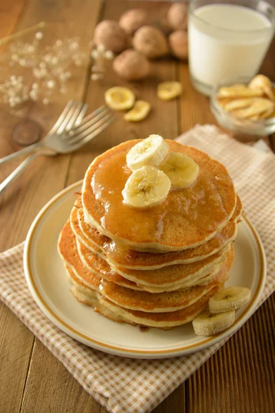 Stack of pancakes with banana slices and honey, on wooden background. Homemade american pancakes, isolated. — Stock Photo, Image