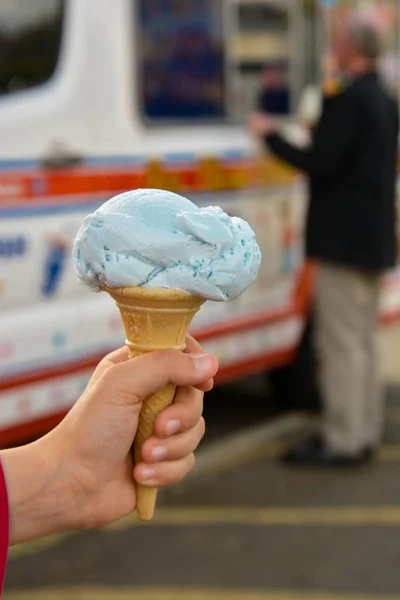 Kinderhand mit blauem Gummi-Eiszapfen, im Freien. Sommerkost. — Stockfoto