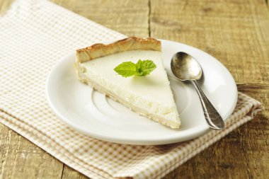 Ahşap masa üzerinde düz cheesecake dilim. Ev yapımı tatlı.