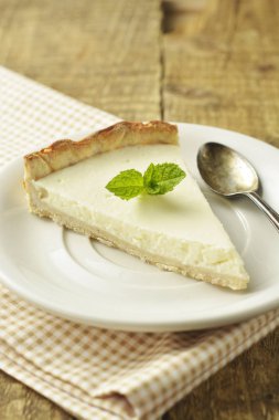 Ahşap masa üzerinde düz cheesecake dilim. Ev yapımı tatlı.