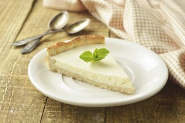 Ahşap masa üzerinde düz cheesecake dilim. Ev yapımı tatlı.