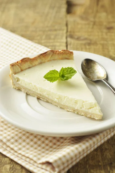 Slice of plain cheesecake on wooden table. Homemade dessert. — Stock Photo, Image