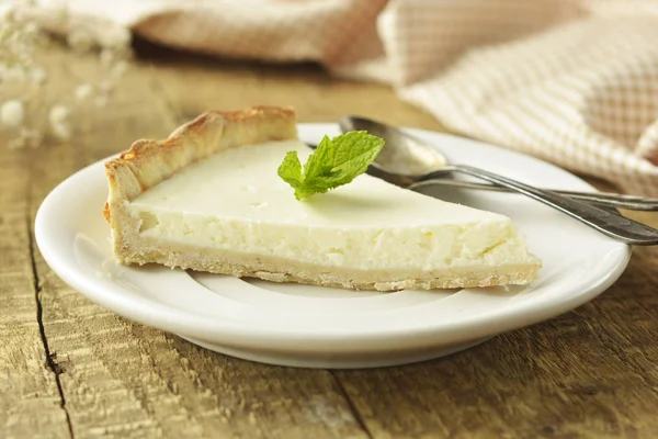 Ahşap masa üzerinde düz cheesecake dilim. Ev yapımı tatlı.
