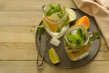 Limonlu ev yapımı limonata, tahta rustik bir masanın üzerinde bir mason kavanozda nane. Yaz içkileri. Kopyalama alanı.