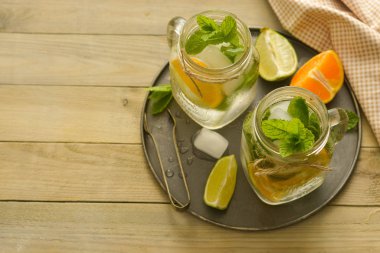 Limonlu ev yapımı limonata, tahta rustik bir masanın üzerinde bir mason kavanozda nane. Yaz içecekleri.