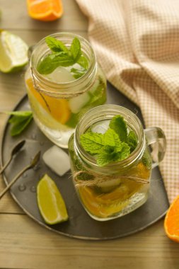 Limonlu ev yapımı limonata, tahta rustik bir masanın üzerinde bir mason kavanozda nane. Yaz içecekleri.