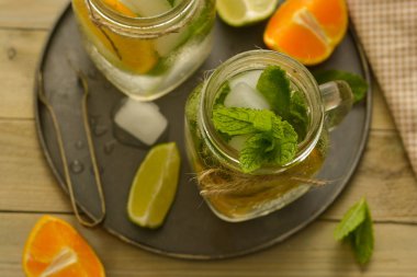 Limonlu ev yapımı limonata, tahta rustik bir masanın üzerinde bir mason kavanozda nane. Yaz içecekleri.