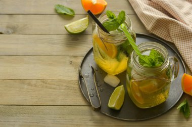 Limonlu ev yapımı limonata, tahta rustik bir masanın üzerinde bir mason kavanozda nane. Yaz içecekleri.