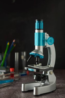 Eğitim, bilim ve çocuk kavramı. Mikroskop siyah arka plan üzerinde izole. Okul laboratuvarında biyoloji eğitimi.