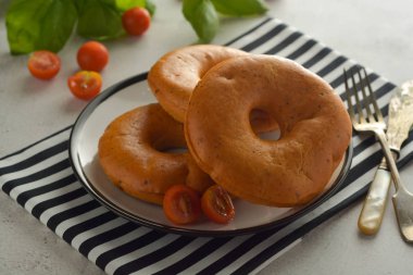 Simitler kahvaltıda fesleğen ve kiraz domates ile parlak tahta izole. Pasta.