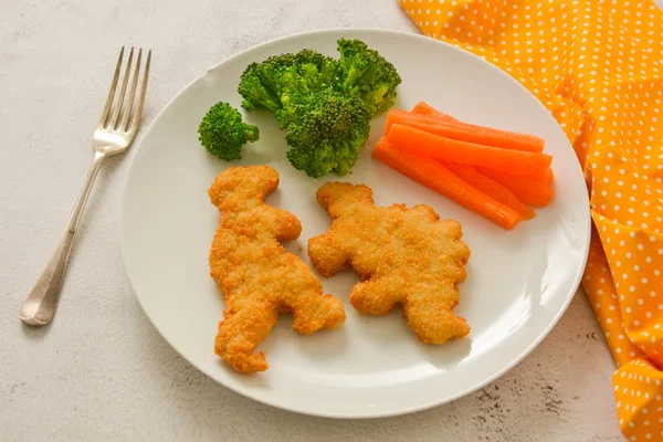 Çocuk yemekleri. sebze ile nuggets. Dinozor şeklinde tavuk, balık veya hindi nuggets, yemeye hazır.