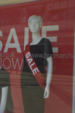 Corby, U.K., June 20, 2019 - mannequin in a shop window with Sale inscription. Sale time fot fashion clothes. clipart
