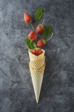 Waffle koni çilek meyve, koyu arka plan üzerinde, üst görünümü.