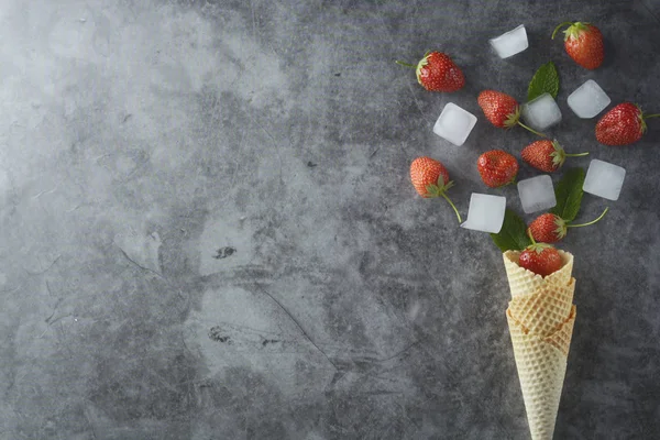 Frutos de fresa en cono de gofre, sobre fondo oscuro, vista superior. Espacio Coy . — Foto de Stock