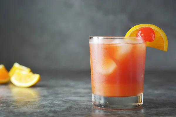 Summer cocktail. Orange juice with mint, syrop, fruit slices and cherry with ice. Dark background. — Stock Photo, Image