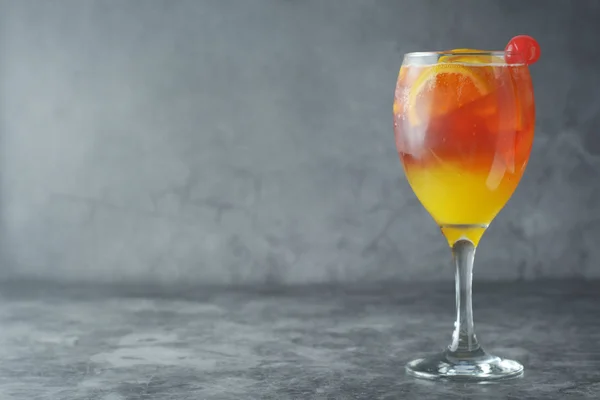 Cocktail d'été. Jus d'orange à la menthe, sirop, tranches de fruits et cerise avec glace. Fond sombre . — Photo