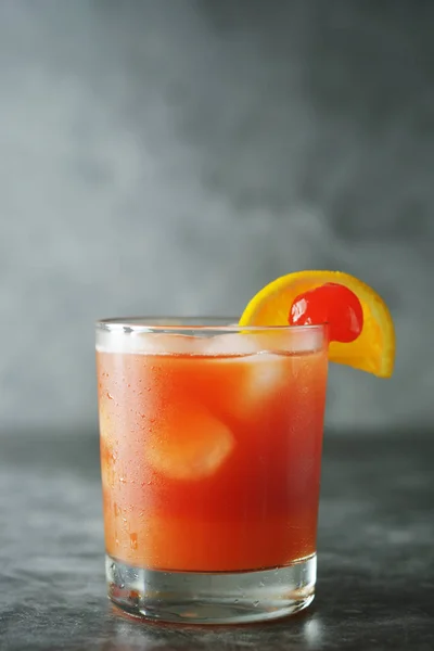 Summer cocktail. Orange juice with mint, syrop, fruit slices and cherry with ice. Dark background. — Stock Photo, Image