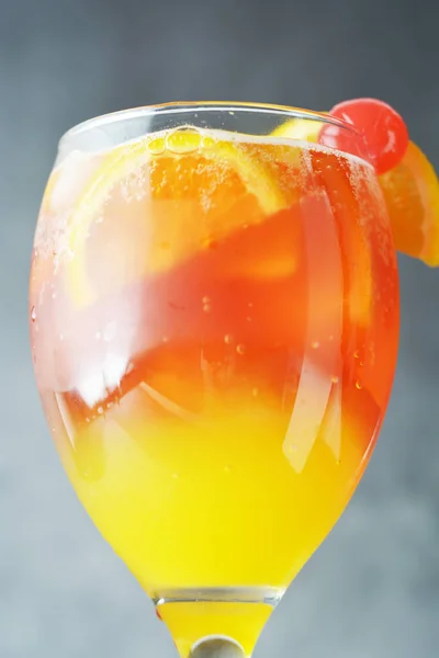 Cocktail d'été. Jus d'orange à la menthe, sirop, tranches de fruits et cerise avec glace. Fond sombre . — Photo