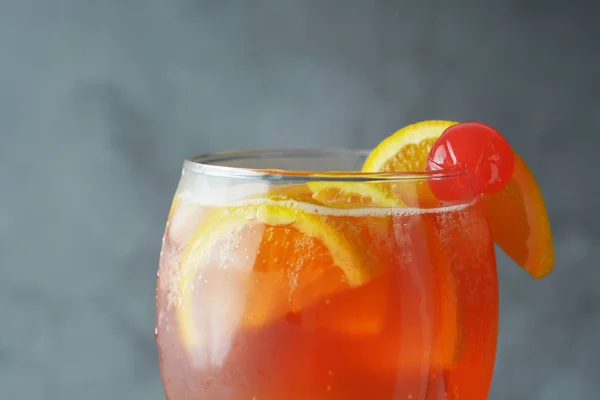 Sommercocktail. Orangensaft mit Minze, Sirup, Fruchtscheiben und Kirsche mit Eis. dunkler Hintergrund. — Stockfoto